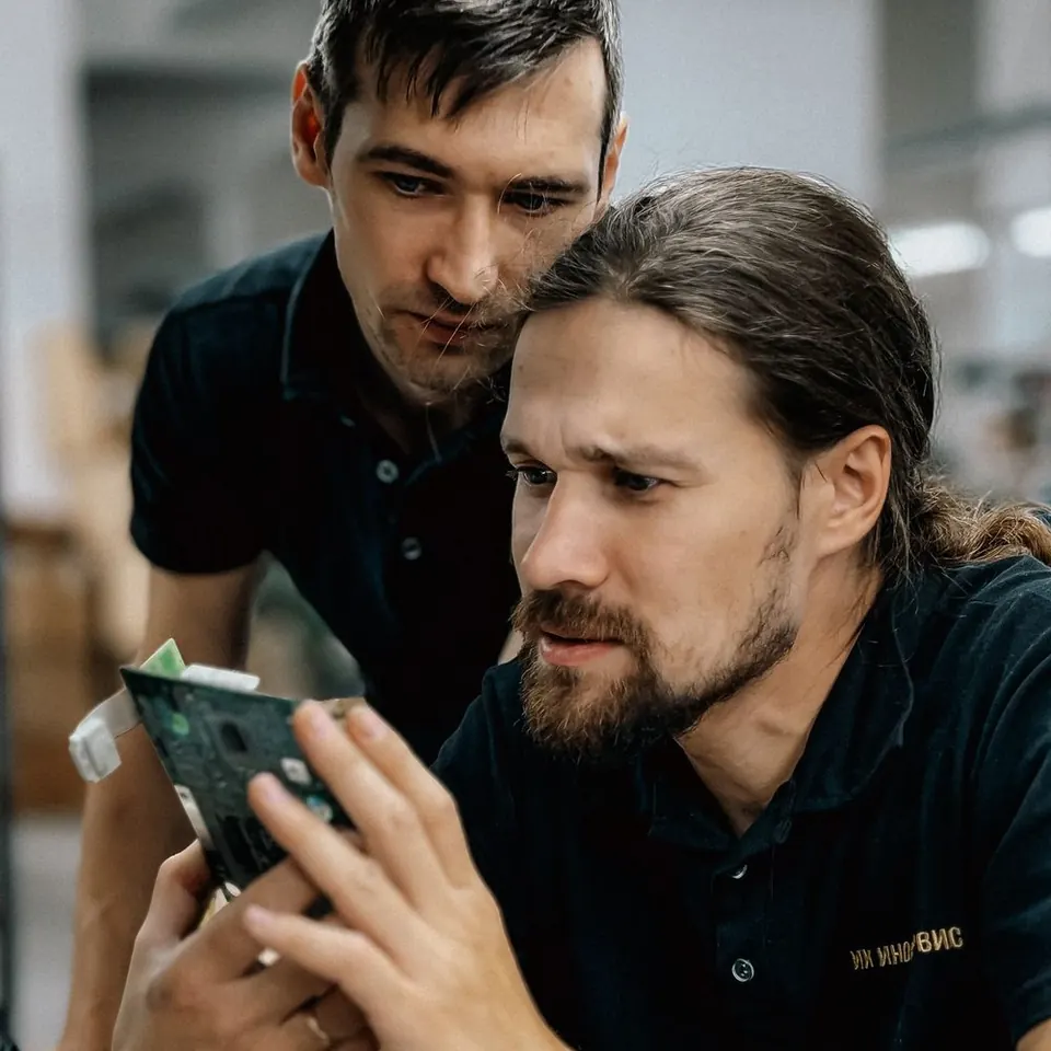 Two technicians looking at a circuit board